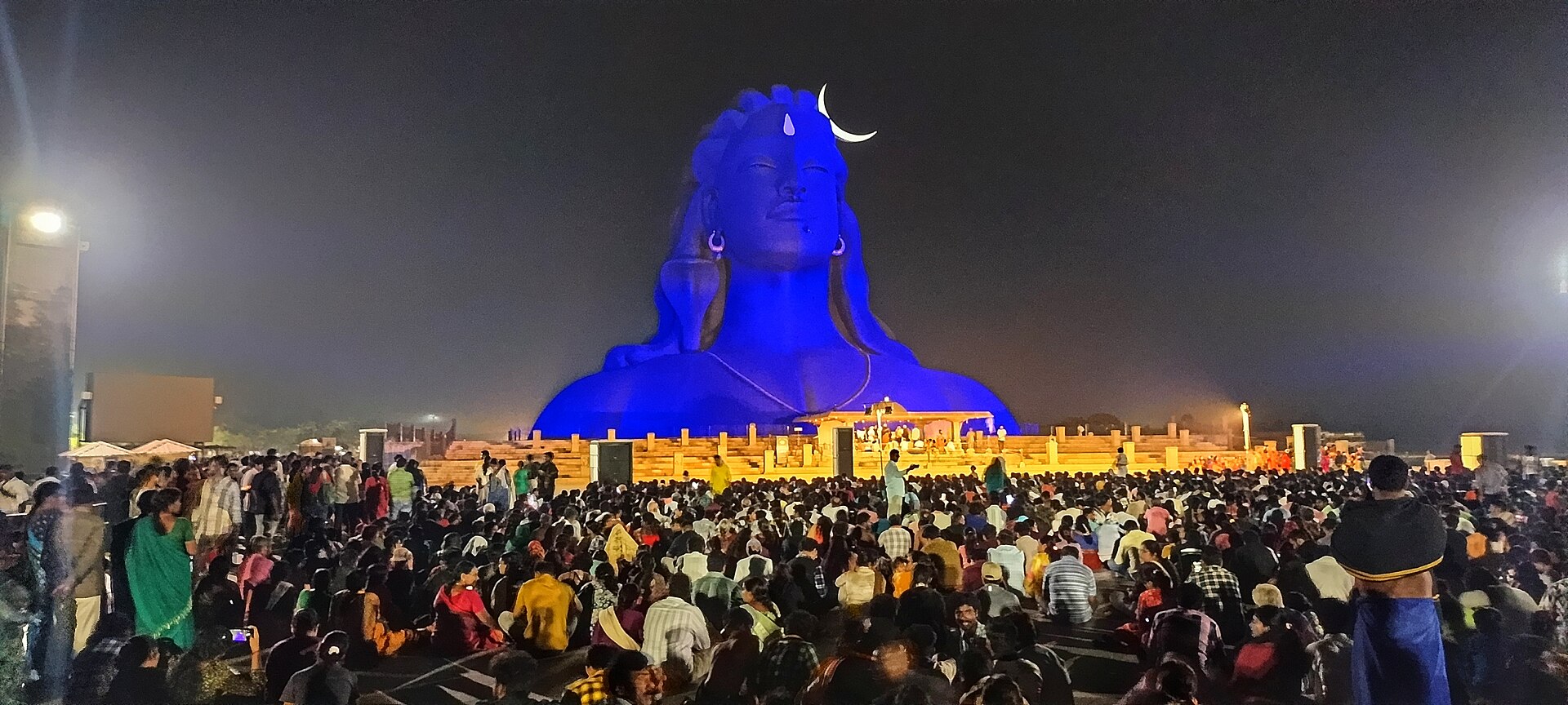 Crowds gathered before the Adiyogi statue glowing blue during the Mahashivratri light show