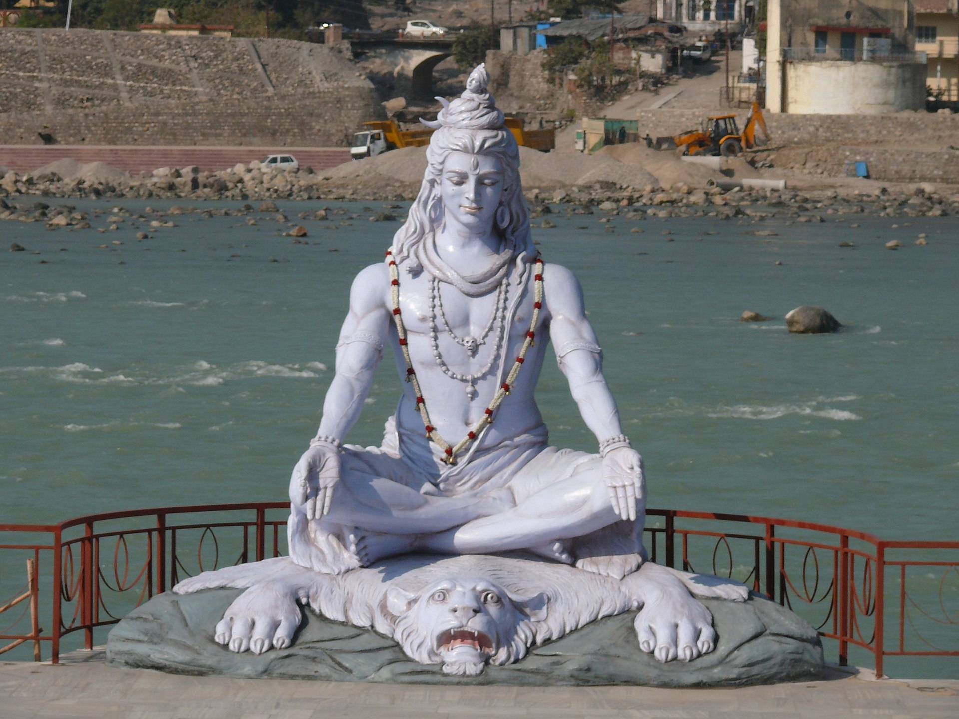 White statue of Shiva meditating in padmasana on the bank of the turquoise Ganga at Parmarth Niketan, Rishikesh